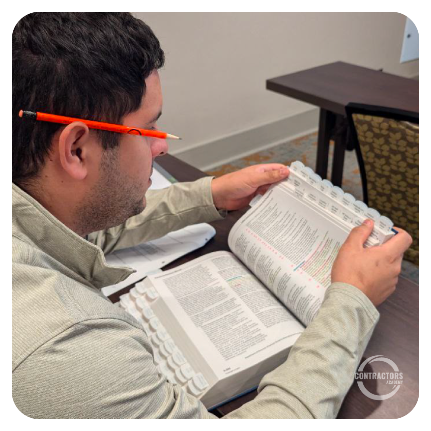Alumno de Contractors Academy navegando libros del examen CILB